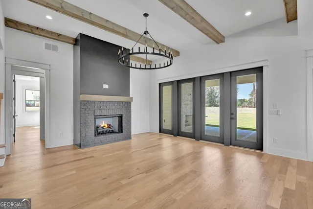 a view of an empty room with a window and fireplace