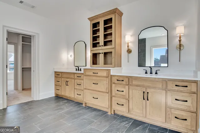 a bathroom with double vanity sink a two mirror a window and a bathtub