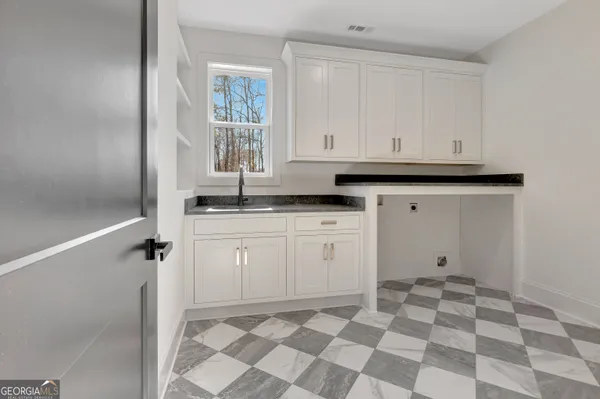a view of a kitchen with white cabinets