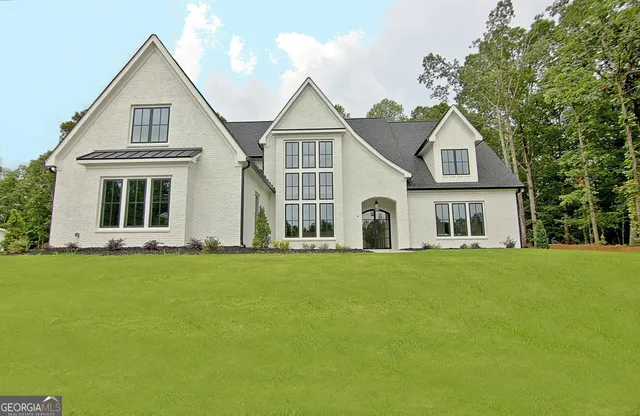 a front view of a house with a garden and yard