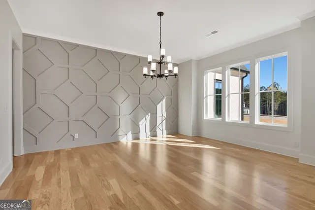 a view of a room with wooden floor and large windows