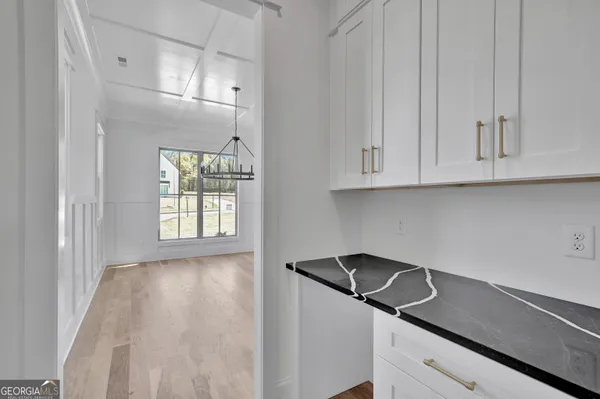 a kitchen with stainless steel appliances granite countertop white cabinets and window