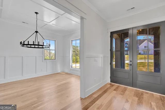 a view of hallway with windows and chandelier