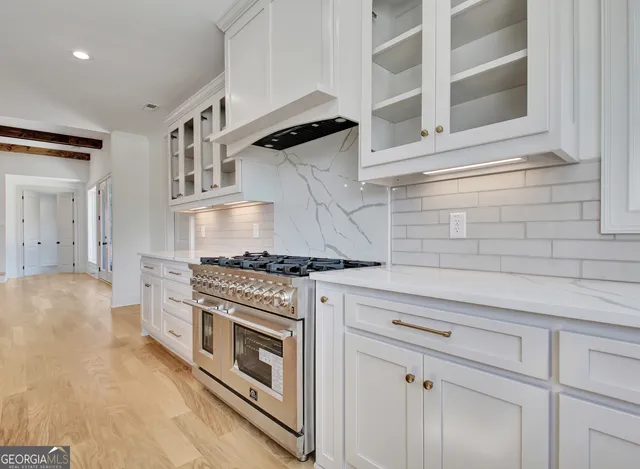 a kitchen with stainless steel appliances granite countertop white cabinets and a stove
