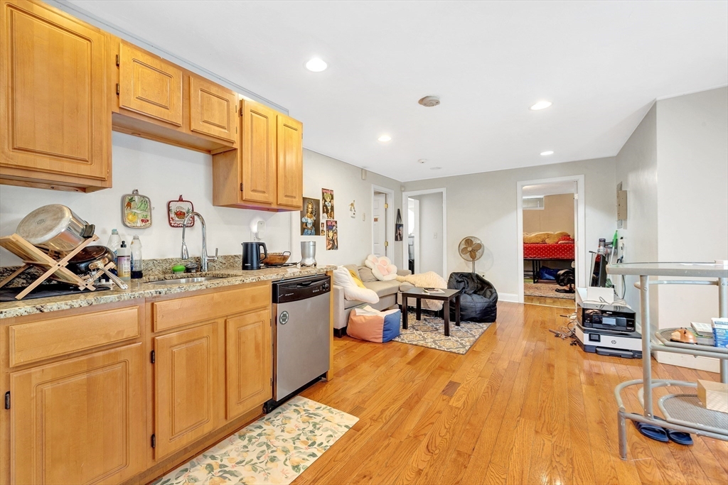 22 Fisher Avenue, Unit 1 Boston, MA 02120 - Photo 6 of 8 a open kitchen with stainless steel appliances granite countertop a stove a sink dishwasher and a microwave with wooden floor