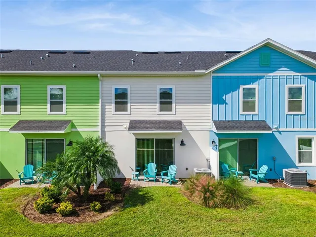 a view of a big house with a big yard and large trees