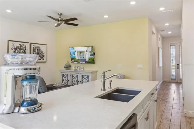 a kitchen with stainless steel appliances a dining table chairs refrigerator and microwave