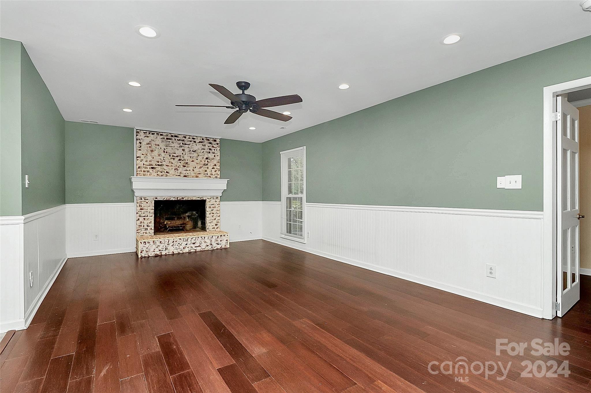 623 Trail Ridge Road Matthews, NC 28105 - Photo 12 of 38 an empty room with wooden floor and a fireplace