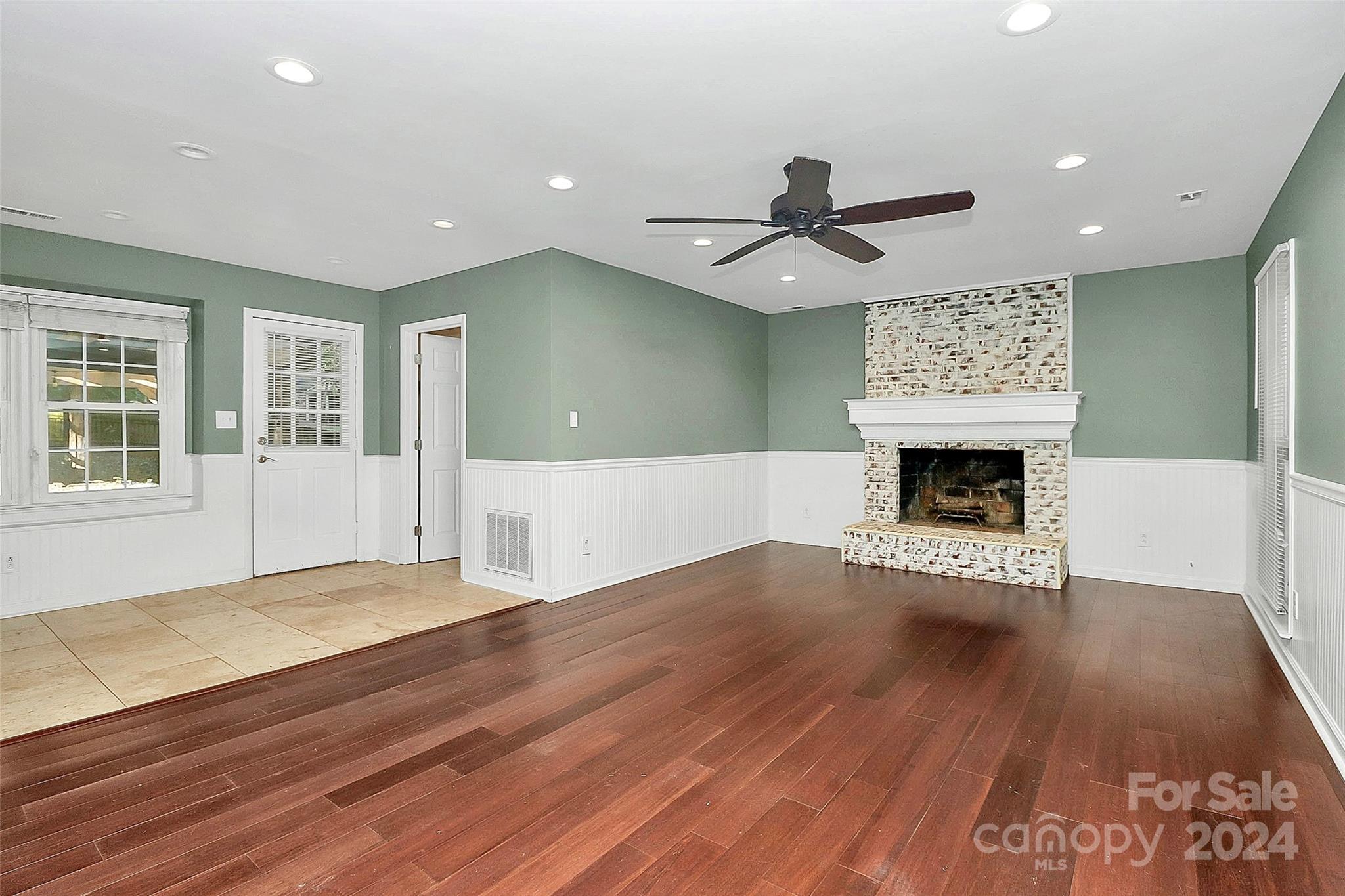 623 Trail Ridge Road Matthews, NC 28105 - Photo 13 of 38 an empty room with wooden floor fireplace and windows