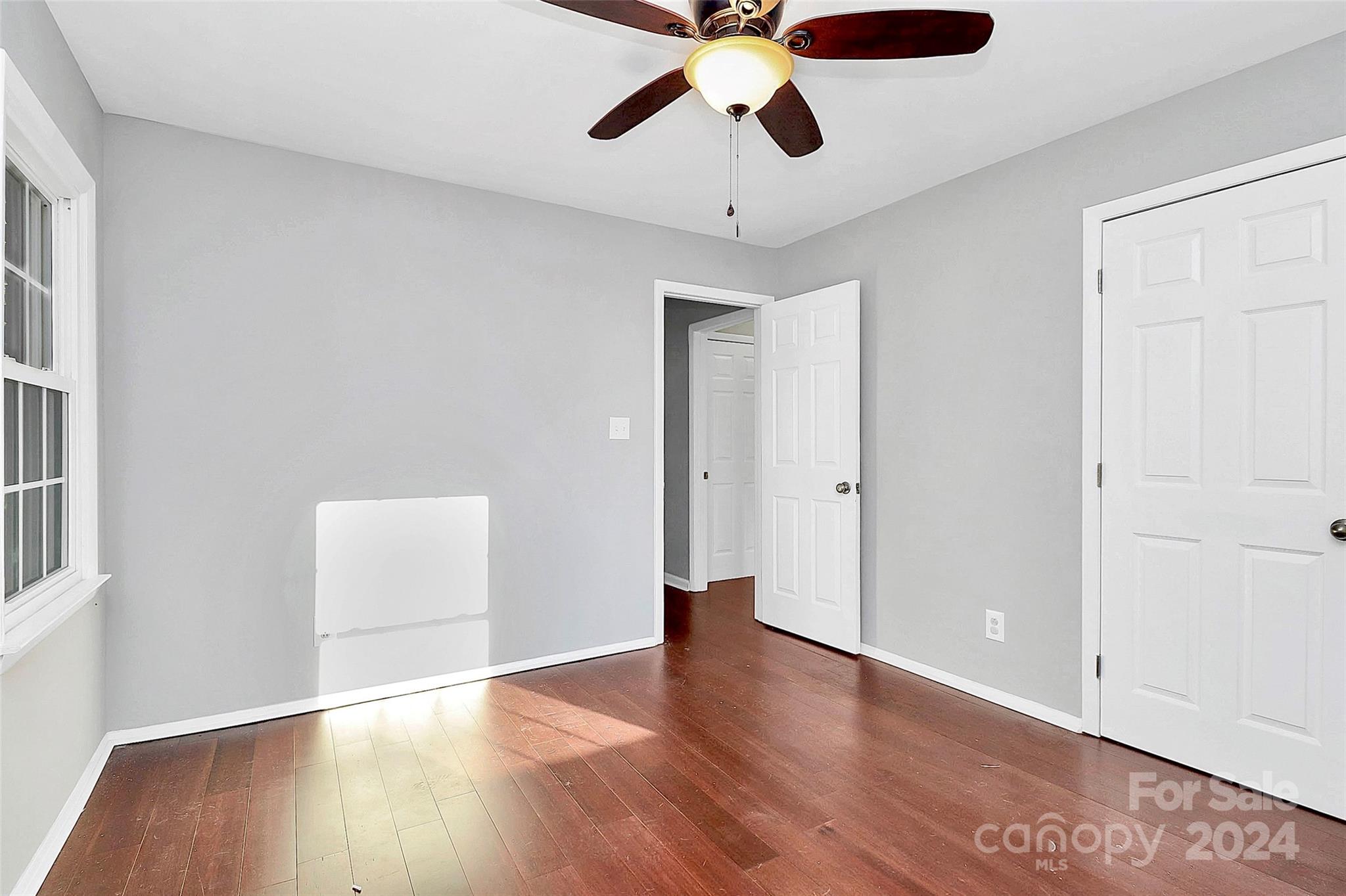 623 Trail Ridge Road Matthews, NC 28105 - Photo 27 of 38 an empty room with wooden floor chandelier fan and windows