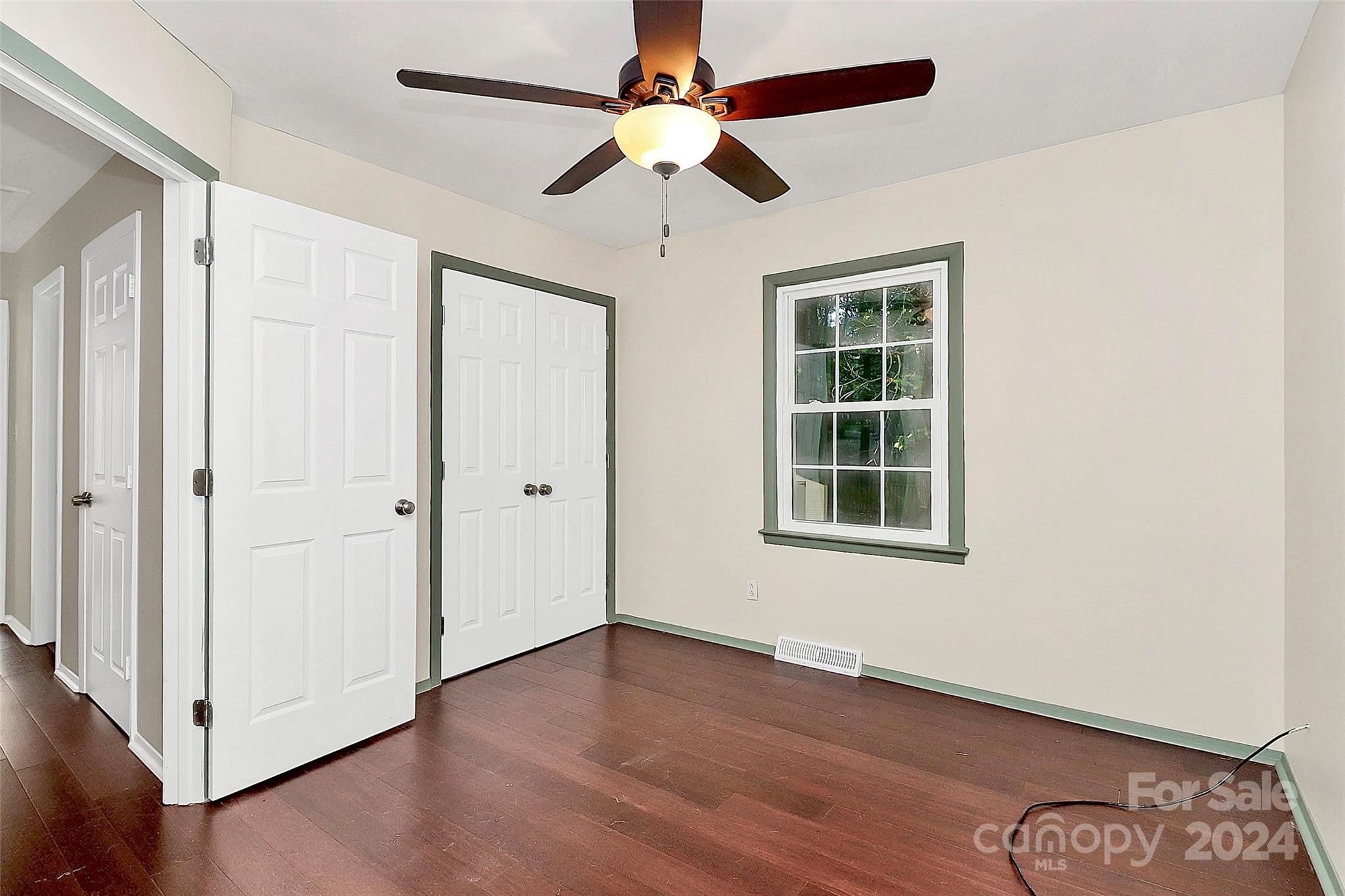 623 Trail Ridge Road Matthews, NC 28105 - Photo 29 of 38 an empty room with wooden floor chandelier fan and windows