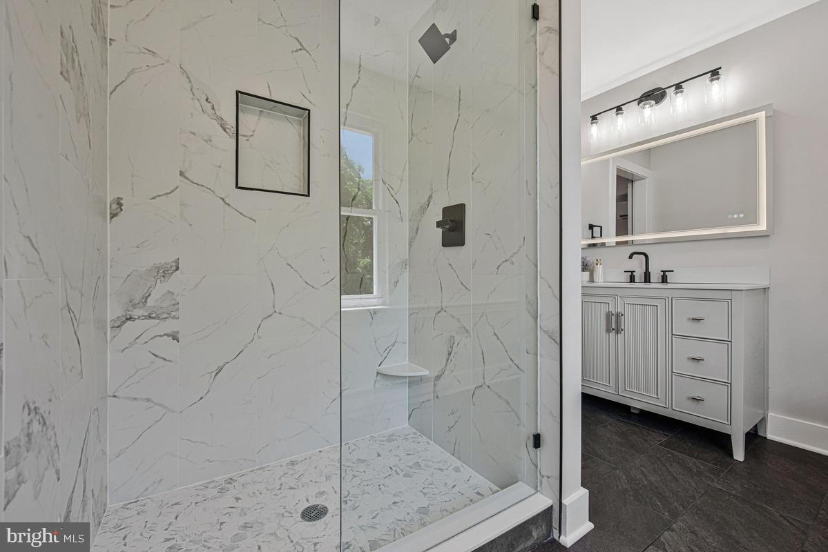 2105 Queens Chapel Road Mount Rainier, MD 20712 - Photo 22 of 33 a bathroom with a double vanity sink a mirror a shower and vanity