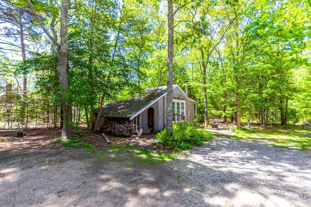 848 Cotuit Road Mashpee, MA 02649 - Photo 25 of 28 a backyard of a house with plants and large trees