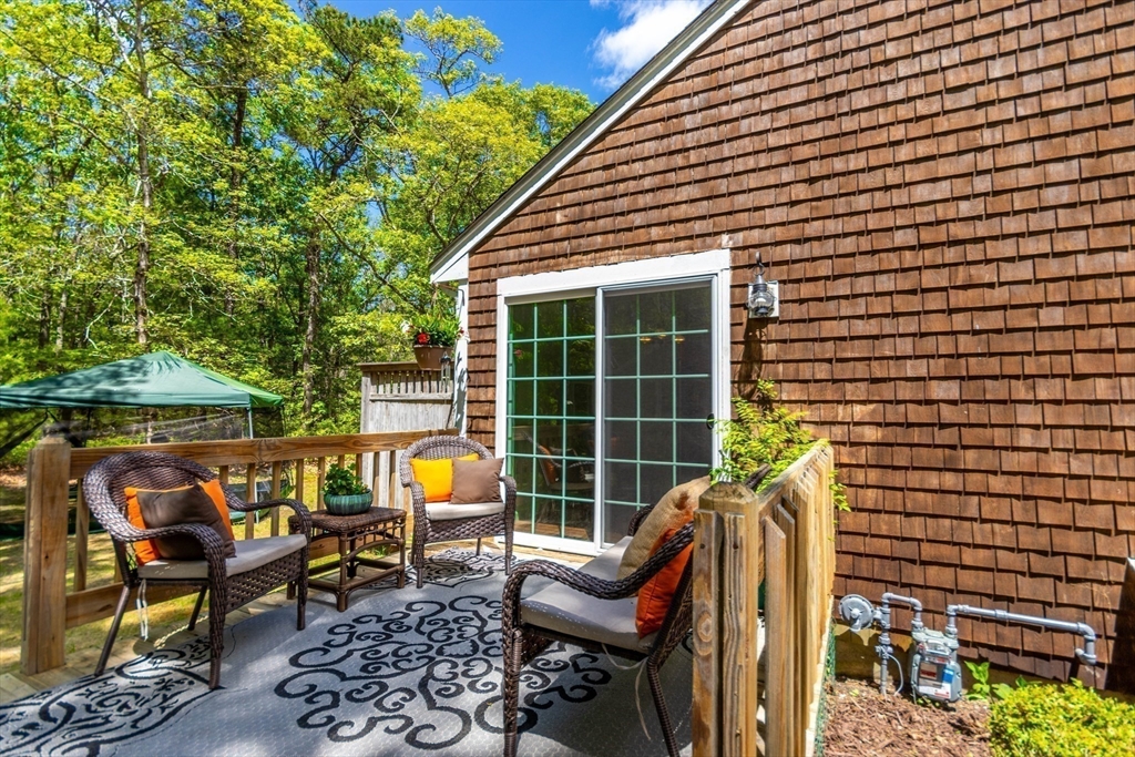 848 Cotuit Road Mashpee, MA 02649 - Photo 5 of 28 a view of a patio with table and chairs and potted plants