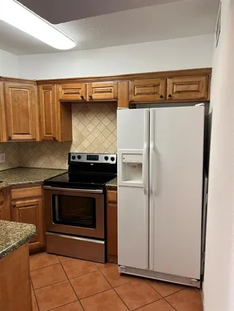 a kitchen with granite countertop a sink a stove and cabinets