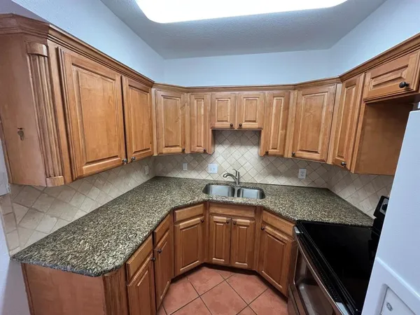 a kitchen with granite countertop a stove and a sink