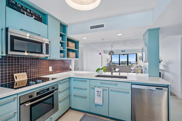 a kitchen with stainless steel appliances a stove microwave and sink