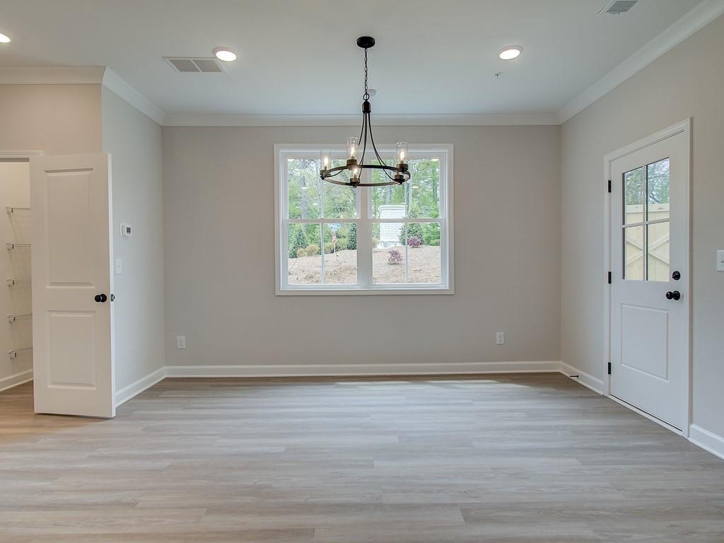 341 Colsen Drive Acworth, GA 30102 - Photo 17 of 36 an empty room with wooden floor windows and a chandelier