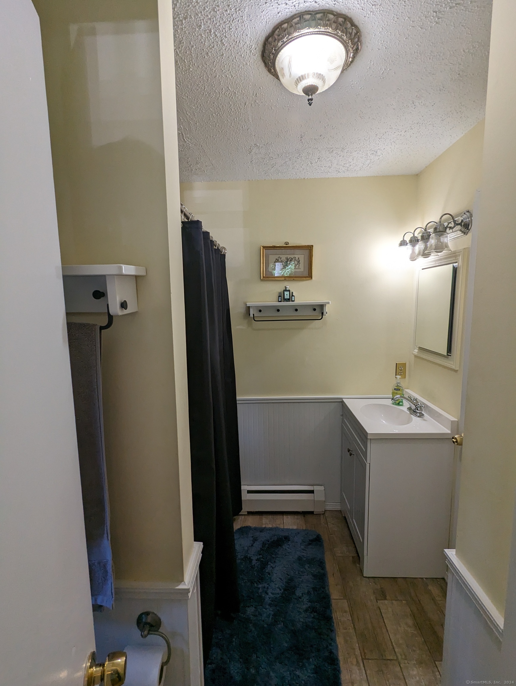 3 Wild Rose Lane, Unit COTTAGE Darien, CT 06820 - Photo 8 of 16 a bathroom with a sink and mirror