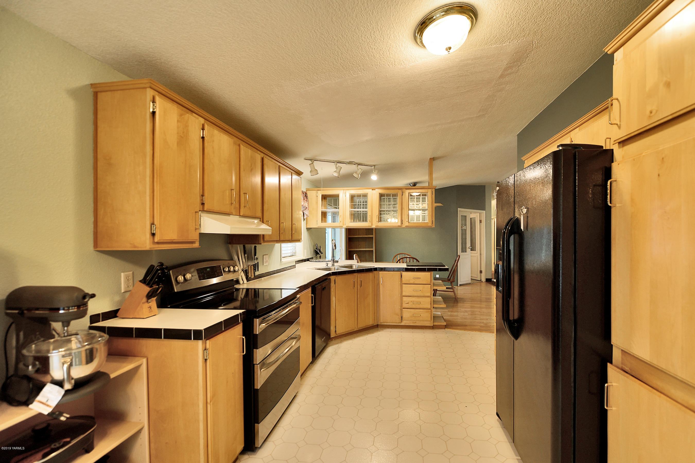 1251 Stone Road Yakima, WA 98908 - Photo 5 of 17 a kitchen with a refrigerator a sink and cabinets