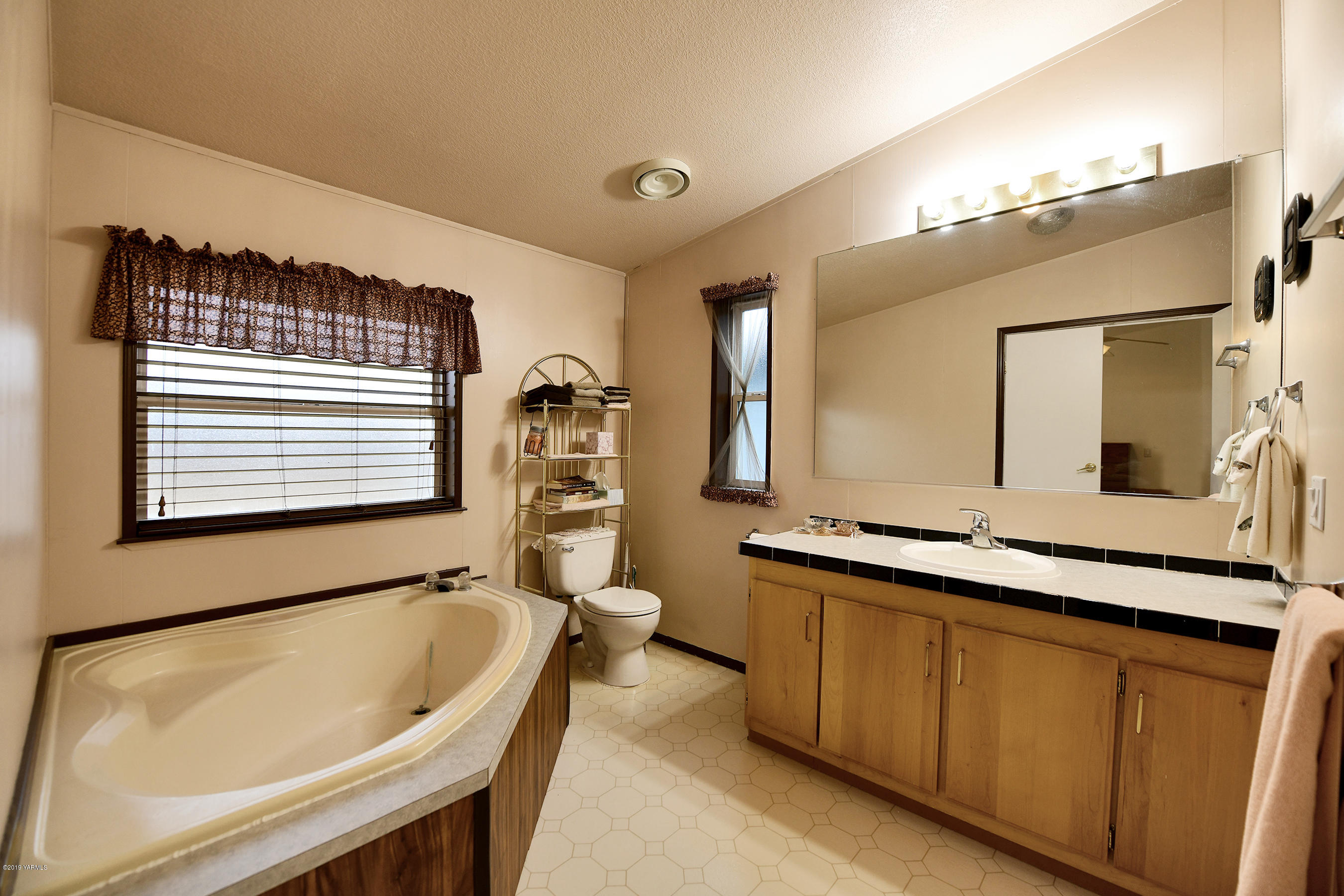 1251 Stone Road Yakima, WA 98908 - Photo 10 of 17 a bathroom with a bathtub sink and mirror