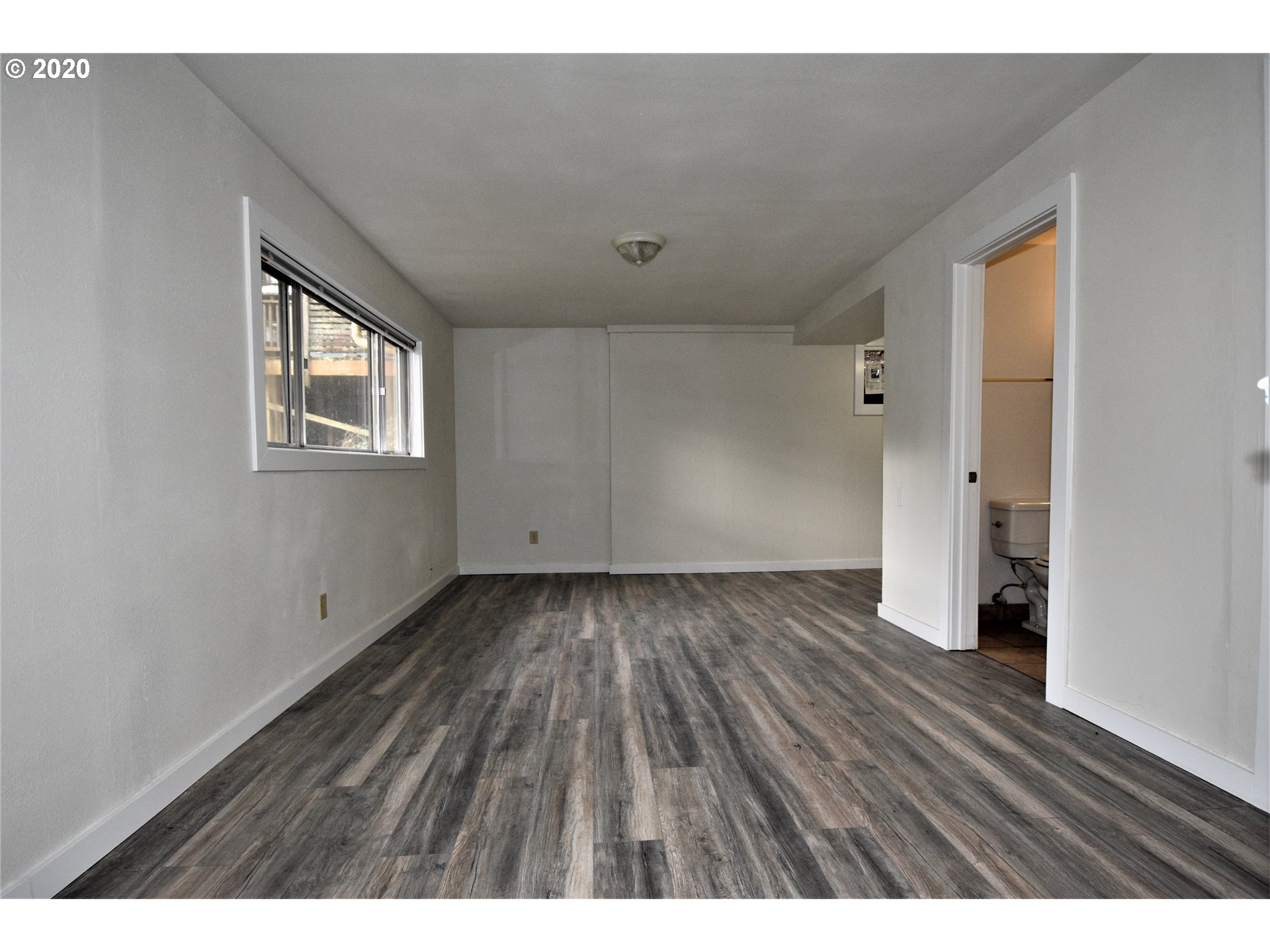 1506 Southwest Broadway Drive Portland, OR 97201 - Photo 10 of 18 a view of an empty room with wooden floor and a window