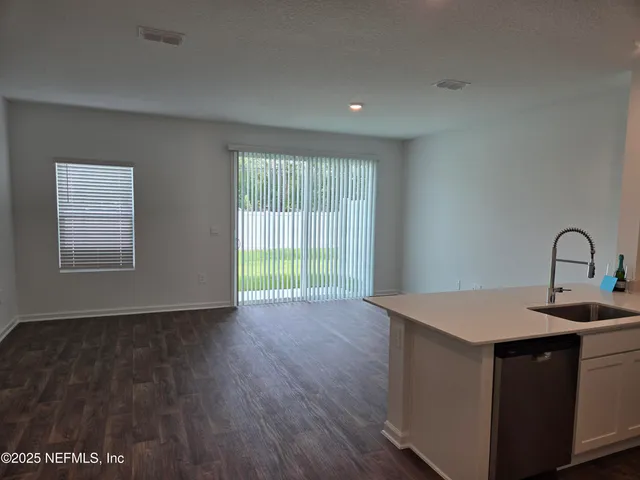 a kitchen with a sink and wooden floor