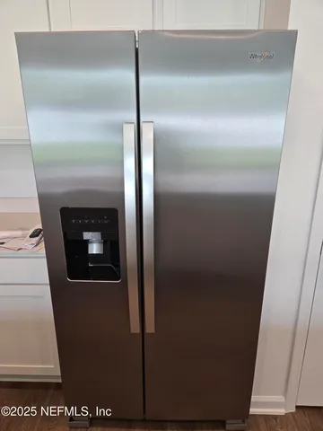 a view of kitchen with refrigerator stove and wooden floor