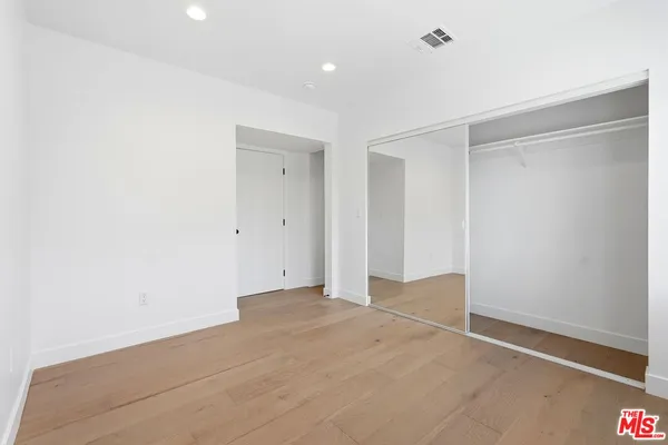 a view of an empty room with wooden floor