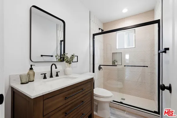 a bathroom with a sink a toilet and shower