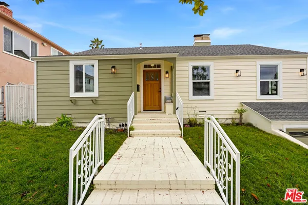a view of a brick house with wooden fence