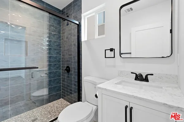 a bathroom with a sink a toilet and mirror