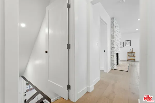 a view of a hallway with wooden floor and staircase