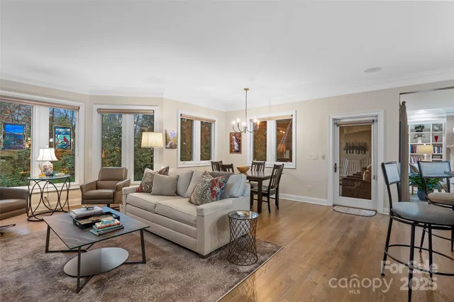 a living room with furniture and a dining table with wooden floor