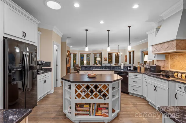 a kitchen with stainless steel appliances granite countertop a sink a stove and a refrigerator