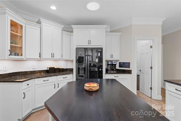 a kitchen with refrigerator and view of living room
