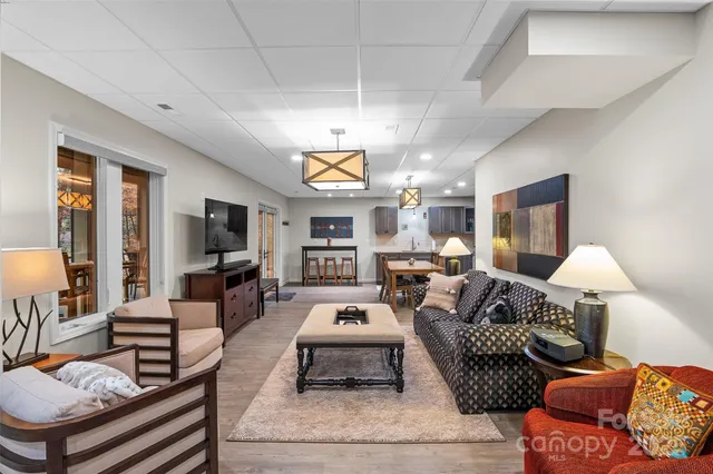 a kitchen with stainless steel appliances kitchen island granite countertop a dining table chairs and a refrigerator