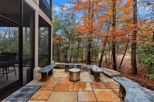 a view of a patio with table and chairs potted plants and large tree