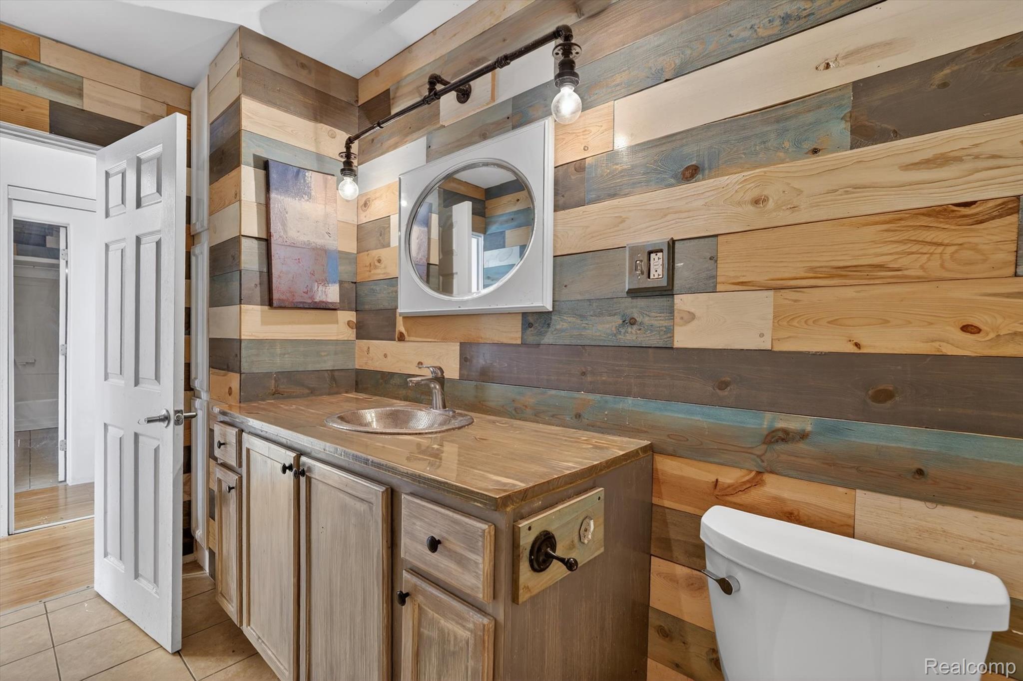 5457 East Frances Road Mount Morris, MI 48458 - Photo 21 of 42 Half bathroom with wood walls, vanity, and light tile patterned floors