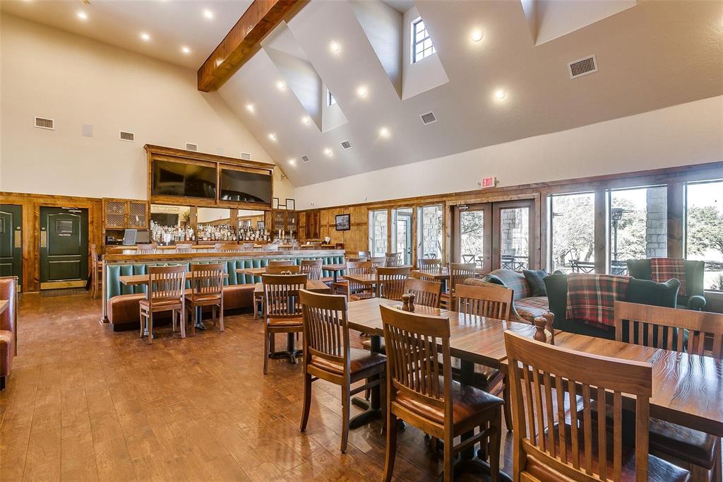 38098 Misty Ridge Drive Whitney, TX 76692 - Photo 16 of 25 Spacious interior featuring wood-finish flooring, a vaulted ceiling with skylights, and a built-in bar with booth seating