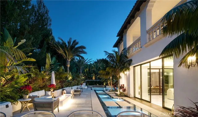 a view of a backyard with couches potted plants and palm tree
