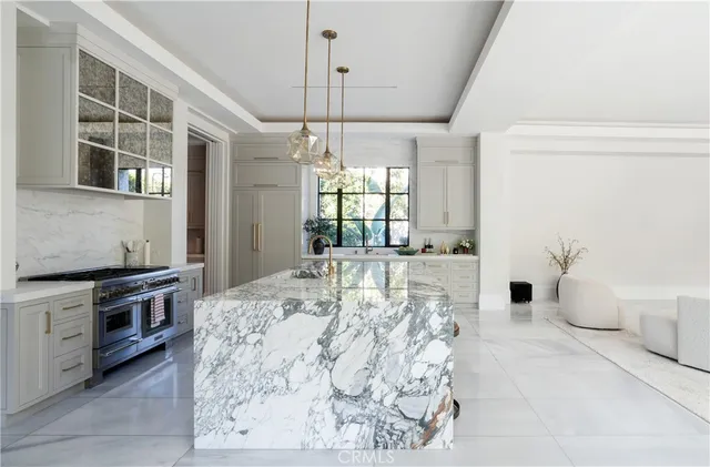 a kitchen with stainless steel appliances granite countertop a stove a sink and a wooden floor