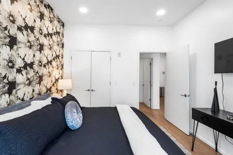 a view of hallway with wooden floor and a chandelier