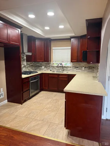 a kitchen with kitchen island granite countertop wooden cabinets a sink and stainless steel appliances