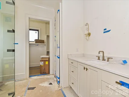 a en suite bathroom with a granite countertop sink and a mirror