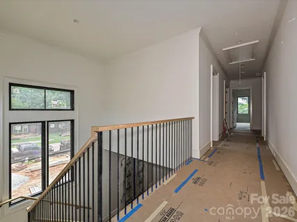 a view of a hallway with wooden floor and a balcony