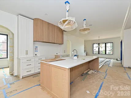 a view of a center island kitchen island a sink wooden floor and living room view