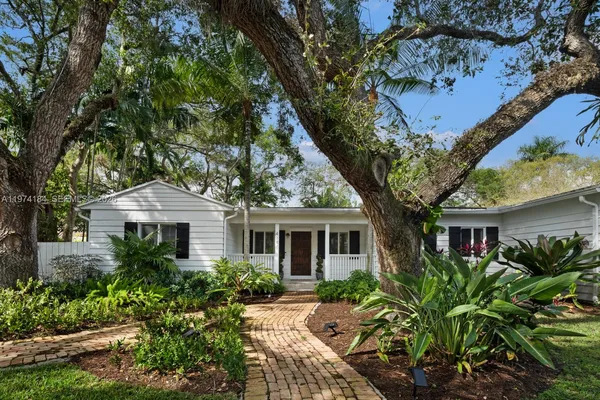 a front view of a house with yard and green space