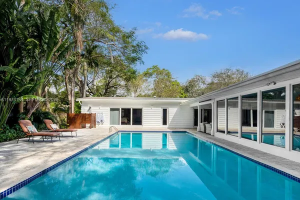 a view of a house with backyard and sitting area