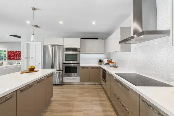a kitchen with stainless steel appliances kitchen island granite countertop a sink and refrigerator